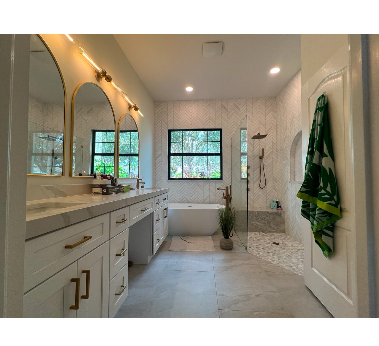 Luxury master bathroom with gold fixtures and freestanding tub