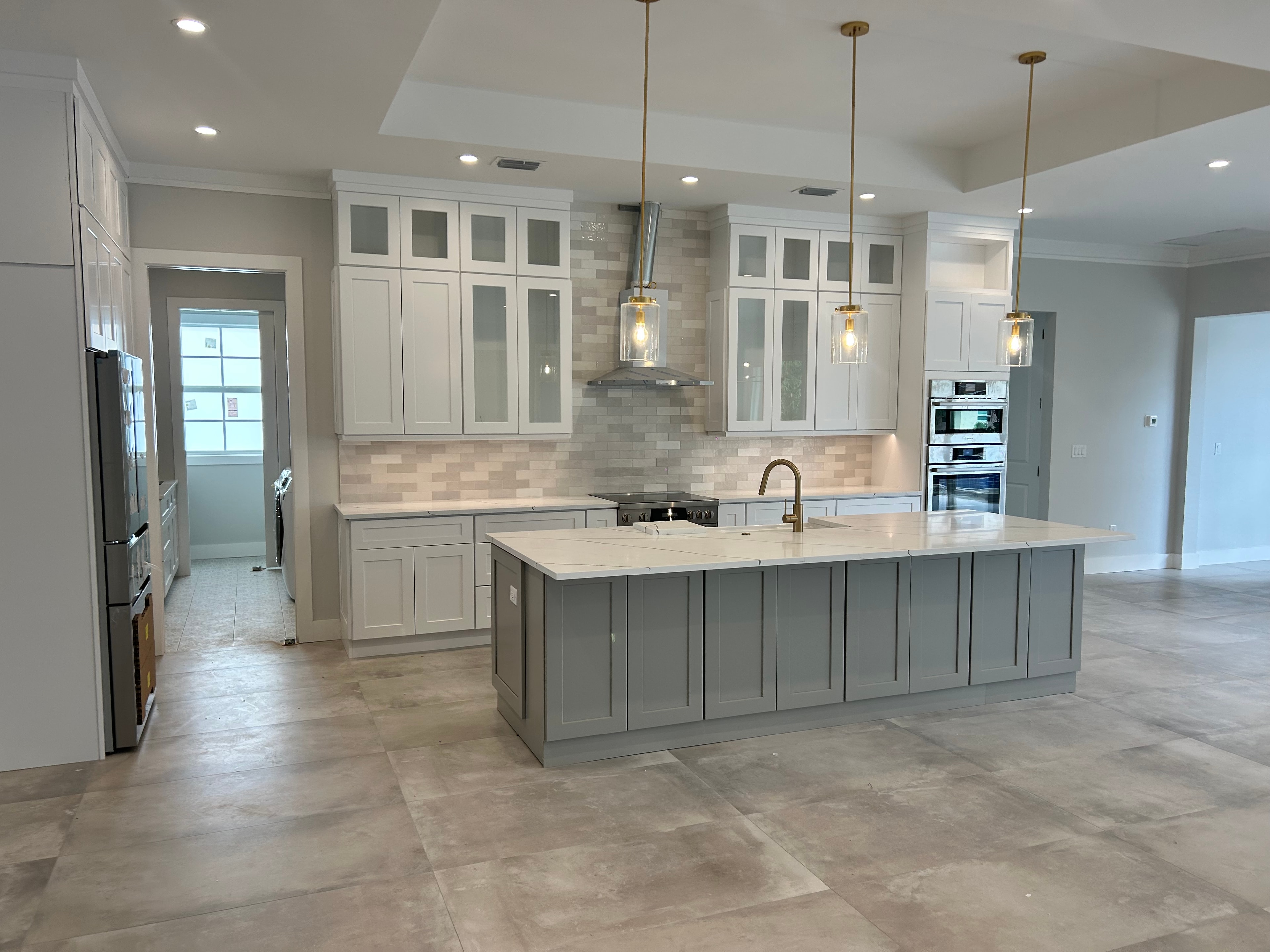 Luxury kitchen with gray island and gold pendant lights